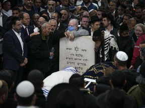 Mourners attend the funeral of Israeli couple Eli Mizrahi and his wife, Natalie, victims of a shooting attack Friday, Jan. 27, in east Jerusalem, at the cemetery in Beit Shemesh, Israel, early Sunday, Jan. 29, 2023.