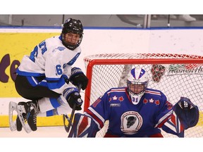 Captain Elias Eisenbarth of victorious South Alberta Hockey Academy jumps high in front of Calgary Buffaloes goalie Kael Svenson during Sunday’s championship contest of the Circle K Classic at Max Bell Centre. Jim Wells/Postmedia