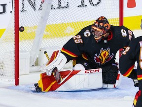 Calgary Flames goaltender Jacob Markstrom watches a shot from Chicago Blackhawks forward Jason Dickinson past him at Scotiabank Saddledome in Calgary on Thursday, Jan. 26, 2023.