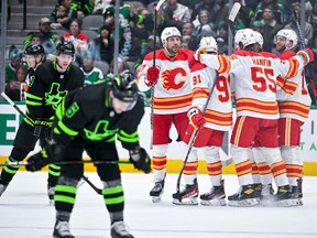 Jan 14, 2023; Dallas, Texas, USA; Calgary Flames left wing Milan Lucic (17) and center Nazem Kadri (91) and defenseman Noah Hanifin (55) and center Jonathan Huberdeau (10) and defenseman Rasmus Andersson (4) celebrate on the ice after Andersson scores a goal against the Dallas Stars during the second period at the American Airlines Center. Mandatory Credit: Jerome Miron-USA TODAY Sports