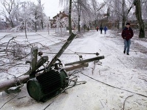 Pedestrians walk past a downed electrical transformer on Jan. 8, 1998, during a devastating ice storm in Kingston, Ont.