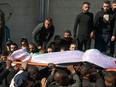 Mourners carry the body, draped in a national flag, of one of nine Palestinians killed during an Israeli raid on the Jenin refugee camp in the occupied West Bank on Jan. 26, 2023.