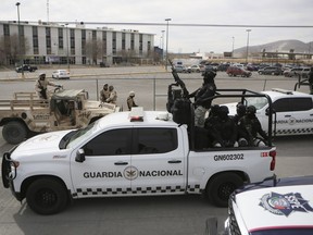 Mexican National Guard stand guard outside a state prison in Ciudad Juarez, Mexico, Sunday Jan 1, 2023.
