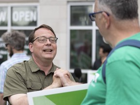 Green Party Leader Mike Schreiner shakes hands following his remarks during the homestretch tour at the intersection of Oxford and Wharncliffe in London, Ont., on Wednesday, June 1, 2022.