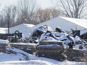 Technicians survey the scene at a propane distribution company in St-Roch-de-l'Achigan, Que., Sunday, Jan. 15, 2023. Police announced late Monday they had found the remains of three people missing since last Thursday's explosion.
