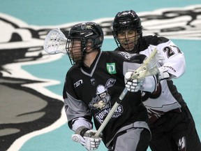 Roughneck Zach Currier dives the ball while defended by Mammoth Scott Carnegie during the first half of action as the Calgary Roughnecks host the Colorado Mammoth at the Saddledome. Friday, February 11, 2022. Brendan Miller/Postmedia