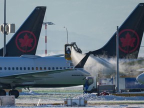 An Air Canada aircraft is de-iced at Vancouver International Airport in Richmond, B.C., Wednesday, Dec. 21, 2022. The Greater Saskatoon Chamber of Commerce is asking the federal competition regulator to investigate Air Canada's decision to end its flights between Saskatoon and Calgary and between Regina and Calgary.