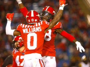 Calgary Stampeders defensive backs Kobe Williams and Brad Muhammad celebrate during a game against the Hamilton Tiger-Cats at McMahon Stadium in Calgary on Oct. 14, 2022.