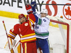 Chris Tanev battles Elias Pettersson during a game against the Vancouver Canucks.