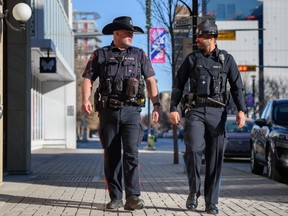 Constable Brad Milne, left, and Alberta sheriff Prabhjot Singh walk outside the Calgary Police Services East Village Safety Hub on Tuesday, Feb. 14, 2023.