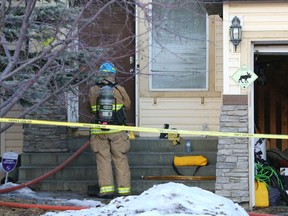 Calgary firefighers and police are shown at a fire scene on Panatella Drive N.W. in Calgary on Friday, February 17, 2023.