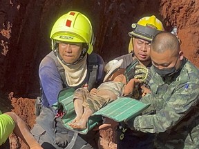 Following an overnight emergency operation, rescue workers and military carry a tot from a deep hole in the northern Thailand province of Tak, 420 kms. (260 miles) north of Bangkok, Tuesday, Feb. 7, 2023.