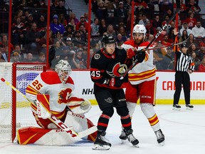 Flames defenceman Noah Hanifin attempts to box out Ottawa Senators forward Parker Kelly during Monday’s game.