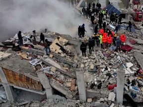Rescuers search through rubble of collapsed buildings following an earthquake, in the rebel-held town of Sarmada, Syria, Monday, Feb. 6, 2023 in this still image obtained from a drone footage.