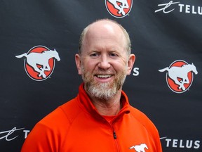 Calgary Stampeders GM/head coach Dave Dickenson smiles at a news conference.