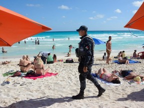 In this file photo, Mexican federal police patrol a beach in Cancun, Mexico, on Jan. 18, 2017, where a shooting occurred in a nightclub the day before.