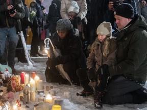 People attend a vigil at a church near the site of a daycare centre where two children lost their lives after a city bus crashed into the building in Laval, Que, Thursday, Feb. 9, 2023.