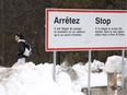 A man waits for transportation at the border at Roxham Rd. on Thursday, February 9, 2023 in Hemmingford, Que.