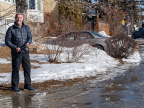 Dean Dolph jokingly tries fishing at the huge puddle formed from the melting snow outside his house in southwest Calgary on Wednesday, March 22, 2023.