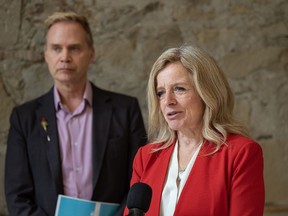 NDP Leader Rachel Notley speaks as former ATB financial VP and chief economist Todd Hirsch stands beside her at a press conference in Calgary on Friday.