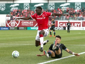 Cavalry FC’s Victor Loturi avoids a tackle from a Pacific FC defender on ATCO Field at Spruce Meadows on Aug. 11, 2021.