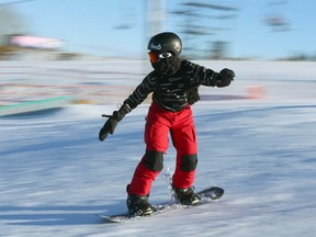 Snowboarders and skiers get their first turns on the hill at Winsport at Canada Olympic Park on Friday, November 26, 2021. The iconic ski hill opened for the season at 1 pm on Friday with limited terrain and crews make snow when possible. Jim Wells/Postmedia