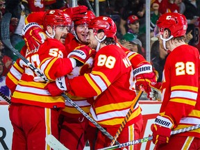Calgary Flames defenseman Mackenzie Vigar, 52, celebrates with teammates after his goal against the Dallas Stars in the second period at the Scotiabank Saddledome in Calgary, March 18, 2023.