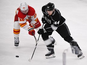 Los Angeles Kings defenceman Mikey Anderson (44) attempts to gain control of the puck during the third period against Calgary Flames centre Elias Lindholm (28) at Crypto.com Arena in Los Angeles on March 20, 2023.