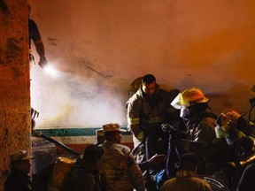 Mexican authorities and firefighters remove injured migrants, mostly Venezuelans, from inside the National Migration Institute (INM) building during a fire, in Ciudad Juarez, Mexico, Monday, March 27, 2023.