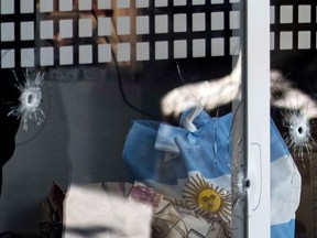 Picture of bullet holes in a window of a supermarket belonging to the family of Antonela Roccuzzo, the wife of Argentine football star Lionel Messi, after attackers fired shots at the facade of the closed premises early in the morning and left a threat message to Messi, in Rosario, Santa Fe Province, Argentina, on March 2, 2023. - Two men attacked the front of a supermarket belonging to the in-laws of Messi and left a written message mentioning the captain of the world champion Argentine team, the mayor of the city Pablo Javkin said. "Messi we are waiting for you. Javkin is a narco, he will not protect you" the handwritten message said. (Photo by AFP)