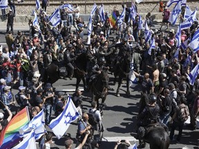 Israeli mounted police officers disperse demonstrators blocking a highway during a protest against plans by Prime Minister Benjamin Netanyahu's government to overhaul the judicial system in Tel Aviv, Israel, Thursday, March 16, 2023.