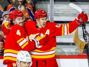 Mikael Backlund des Flames de Calgary célèbre avec son coéquipier Rasmus Andersson après avoir marqué contre les Oilers d'Edmonton au hockey de la LNH au Scotiabank Saddledome à Calgary le mardi 27 décembre 2022.