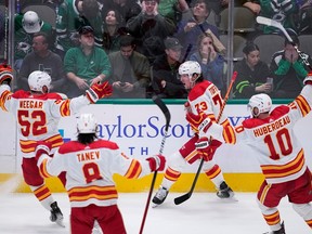 Calgary Flames-aanvaller Tyler Toffoli viert feest met MacKenzie Weegar, Chris Tanev en Jonathan Huberdeau na het scoren van het winnende doelpunt tegen de Dallas Stars in de laatste seconden van de derde periode in het American Airlines Center in Dallas op maandag 6 maart 2023.