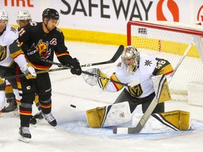 Calgary Flames-Stürmer Mikael Backlund kämpft am Donnerstag, den 23. März 2023, im Scotiabank Saddledome in Calgary gegen Logan Thompson, Torhüter der Vegas Golden Knights.