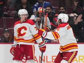 Calgary Flames forward Tyler Toffoli, left, celebrates his game-winning goal in overtime against the Vancouver Canucks with defenceman Rasmus Andersson at Rogers Arena in Vancouver on Friday, March 31, 2023.