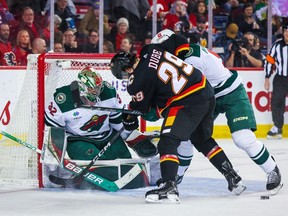 Mar 4, 2023; Calgary, Alberta, CAN; Calgary Flames center Dillon Dube (29) and Minnesota Wild defenseman Jake Middleton (5) battle for the puck in front of Minnesota Wild goaltender Filip Gustavsson (32) during the second period at Scotiabank Saddledome. Sergei Belski-USA TODAY Sports