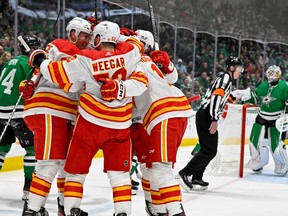 The Calgary Flames celebrate a goal by Nick Ritchie (left), his first for the team since being acquired in a trade, against the Dallas Stars at American Airlines Center on Monday, March 6, 2023.