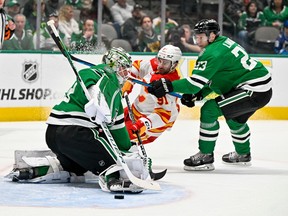Calgary Flames forward Nazem Kadri is checked by Dallas Stars defenceman Esa Lindell as goaltender Jake Oettinger allows a goal to Flames forward Nick Ritchie (not pictured) at American Airlines Center in Dallas on Monday, March 6, 2023.
