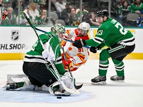 Calgary Flames forward Nazem Kadri is checked by Dallas Stars defenceman Esa Lindell as goaltender Jake Oettinger allows a goal to Flames forward Nick Ritchie (not pictured) at American Airlines Center in Dallas on Monday, March 6, 2023.