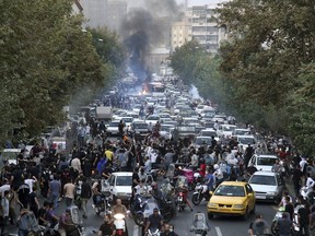 In this Wednesday, Sept. 21, 2022, photo taken by an individual not employed by the Associated Press and obtained by the AP outside Iran, protesters chant slogans during a protest over the death of a woman who was detained by the morality police, in downtown Tehran, Iran.