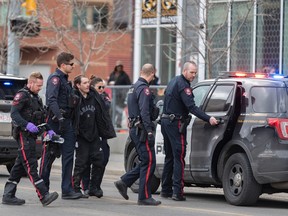 Calgary Police officers take a suspect of multiple stabbings into custody in East Village on Monday, April 3, 2023.