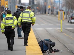 Third-party security guards come to the aid of a man who fell onto the tracks at the City Hall station on Monday.
