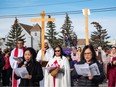 Catholic devotees participate in the Way of the Cross procession in the neighbourhood of Our Lady of Fatima Parish in Calgary on Friday.