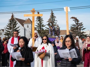 Catholic devotees participate in the Way of the Cross procession in the neighbourhood of Our Lady of Fatima Parish in Calgary on Friday.