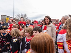 Premier Danielle Smith, vertegenwoordigers van Calgary Flames, jongeren van de Calgary Flames Foundation, gemeenteraadsleden en andere functionarissen poseren voor een foto na de persconferentie voor een aankondiging over een toekomstig evenementencentrum in Calgary op dinsdag 25 april.