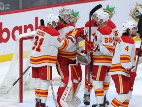 WINNIPEG, CANADA - APRIL 5: Nazem Kadri #91, Trevor Lewis #22 and Nick Ritchie #27 of the Calgary Flames congratulate netminder Jacob Markstrom #25 after defeating the Winnipeg Jets during a game on April 5, 2023 at Canada Life Centre in Winnipeg, Manitoba, Canada.