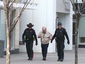Calgary Sun columnist Rick Bell (C) joins Calgary Police Service Sgt .Mike Anderson (L) and Acting Sgt. Eric LeGreeley (Sheriff's office) (R) on Wednesday, April 12, 2023 near the Sheldon Chumir Centre in downtown Calgary.