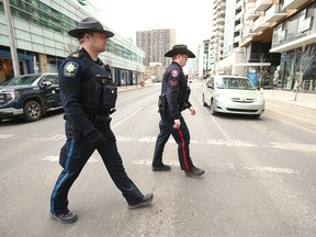 Sergeant Mike Anderson van de politie van Calgary en waarnemend sergeant Eric LeGreeley (kantoor van de sheriff) lopen op woensdag 13 april 2023 in de buurt van het Sheldon Chumir Centre in het centrum van Calgary.