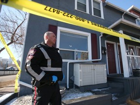 A Calgary Police Service officer gathers evidence where bullets struck a residence at 9A Street and 3 Avenue N.W. in Kensington on Thursday, April 13, 2023.