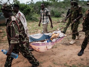 Security personnel carry a rescued young person from the forest in Shakahola, outside the coastal town of Malindi, on April 23, 2023.
